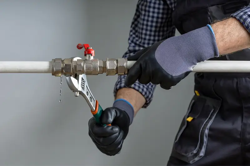 Plumber shutting off a water valve on a pipe