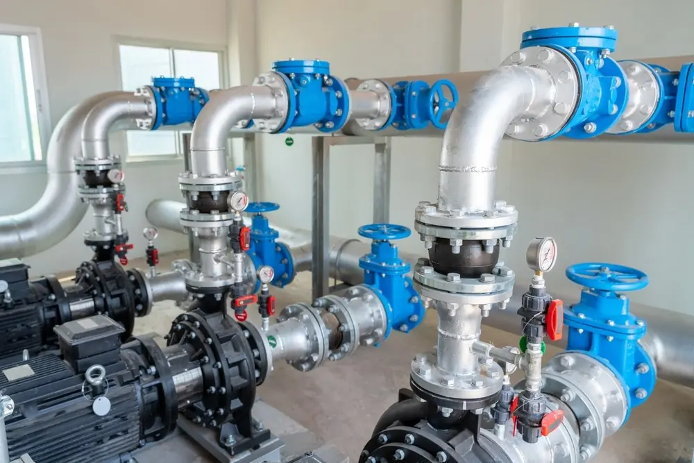 Commercial plumbing pipes and valves in a mechanical room